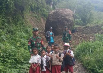 Babinsa Koramil Ruteng Bantu Anak Sekolah Seberangi Longsoran